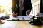 man signing papers in office